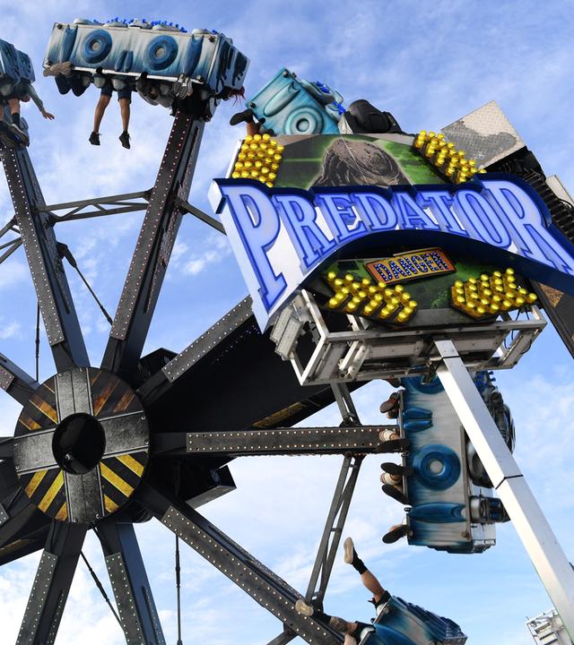 Eine Art Riesenrad, allerdings nicht mit klassischen Gondeln, sondern Sitzen, in denen die Fahrgäste auch kopfüber hängen.