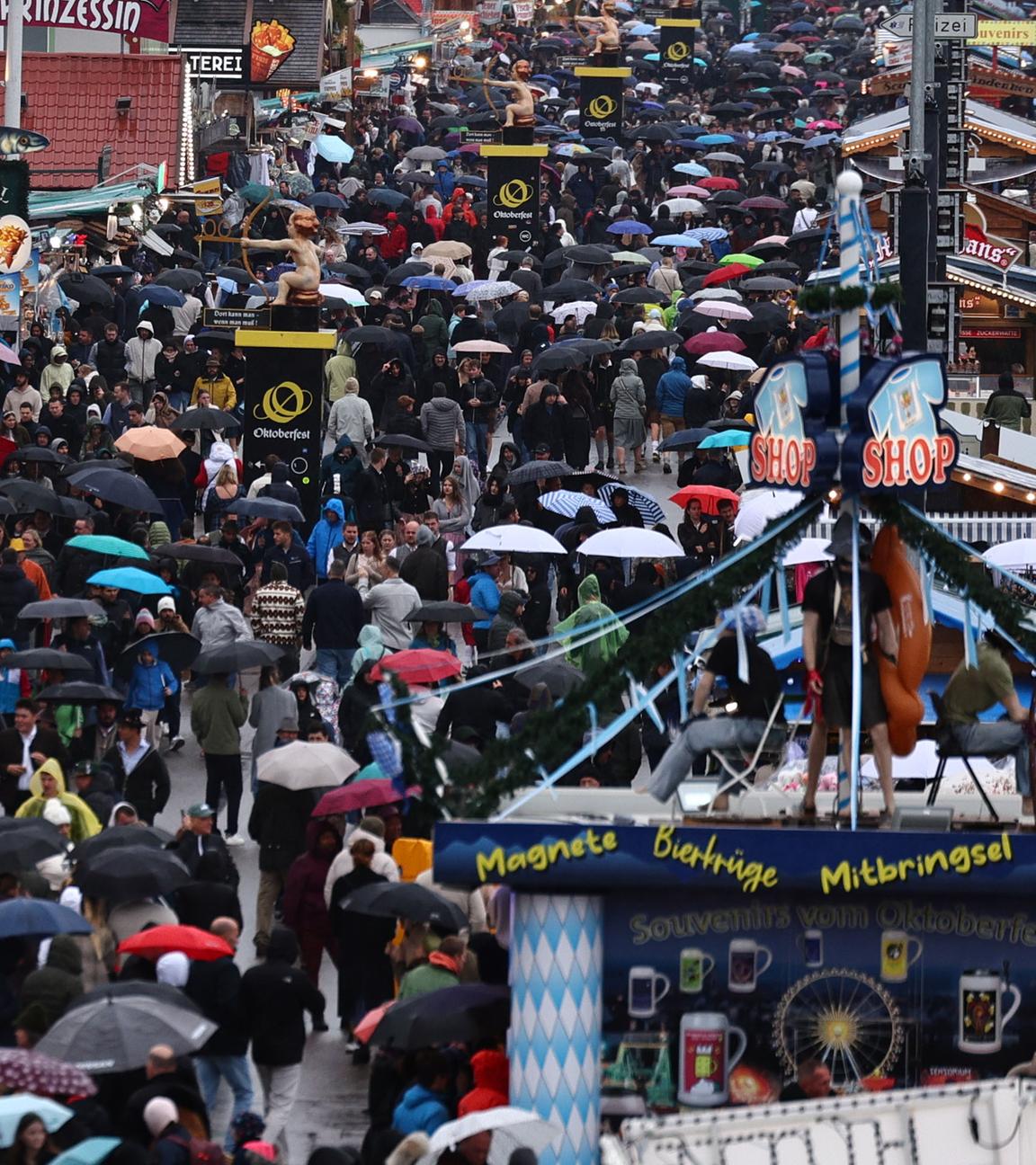 Ganz viele Menschen auf der Wiesn, mit Regenschirmen