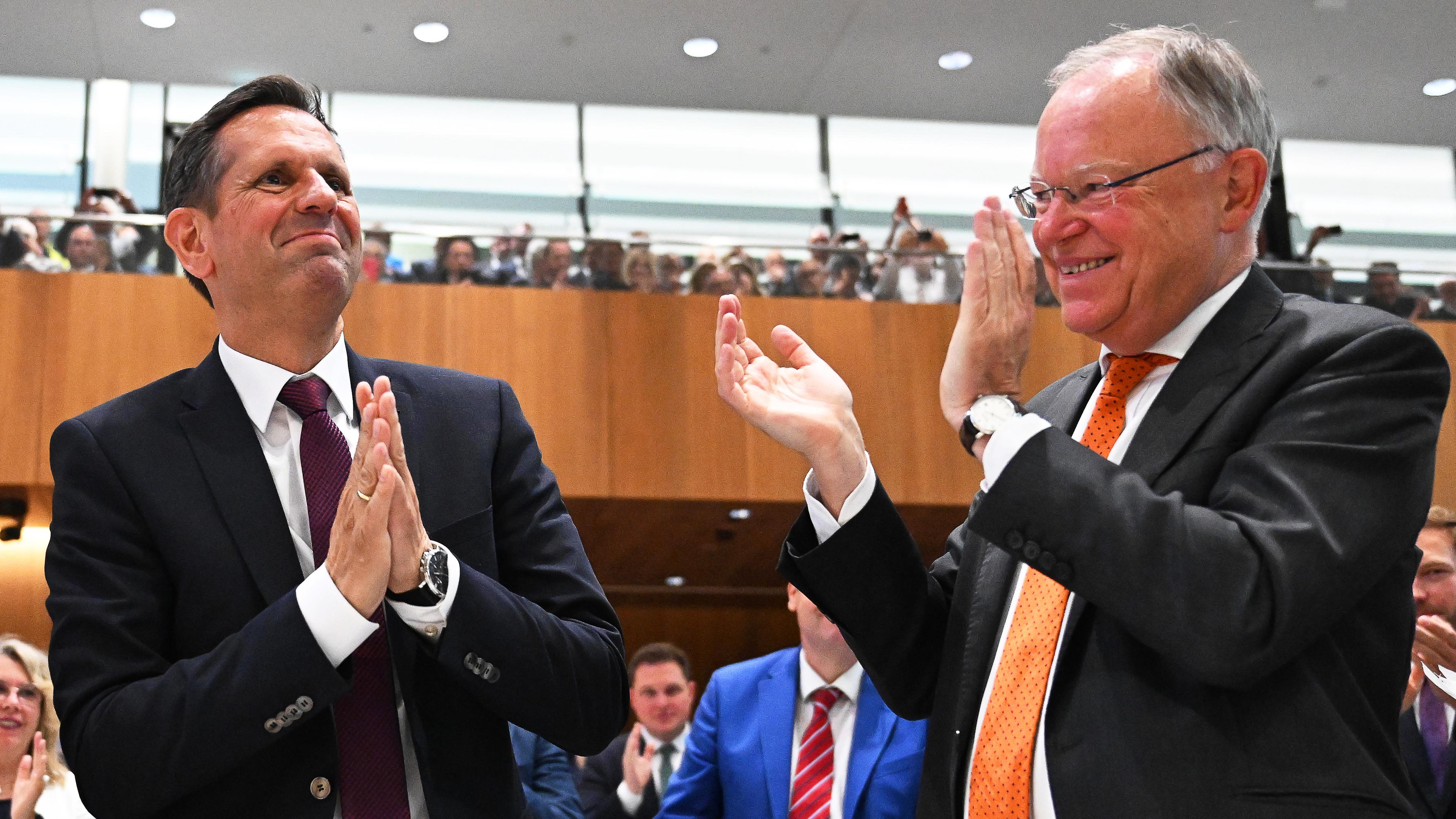 Olaf Lies (SPD, l) nimmt nach seiner Wahl zum Ministerpräsidenten von Niedersachsen den Applaus von Stephan Weil (SPD), scheidender Ministerpräsident von Niedersachsen, während der Sitzung des Niedersächsischen Landtags entgegen.