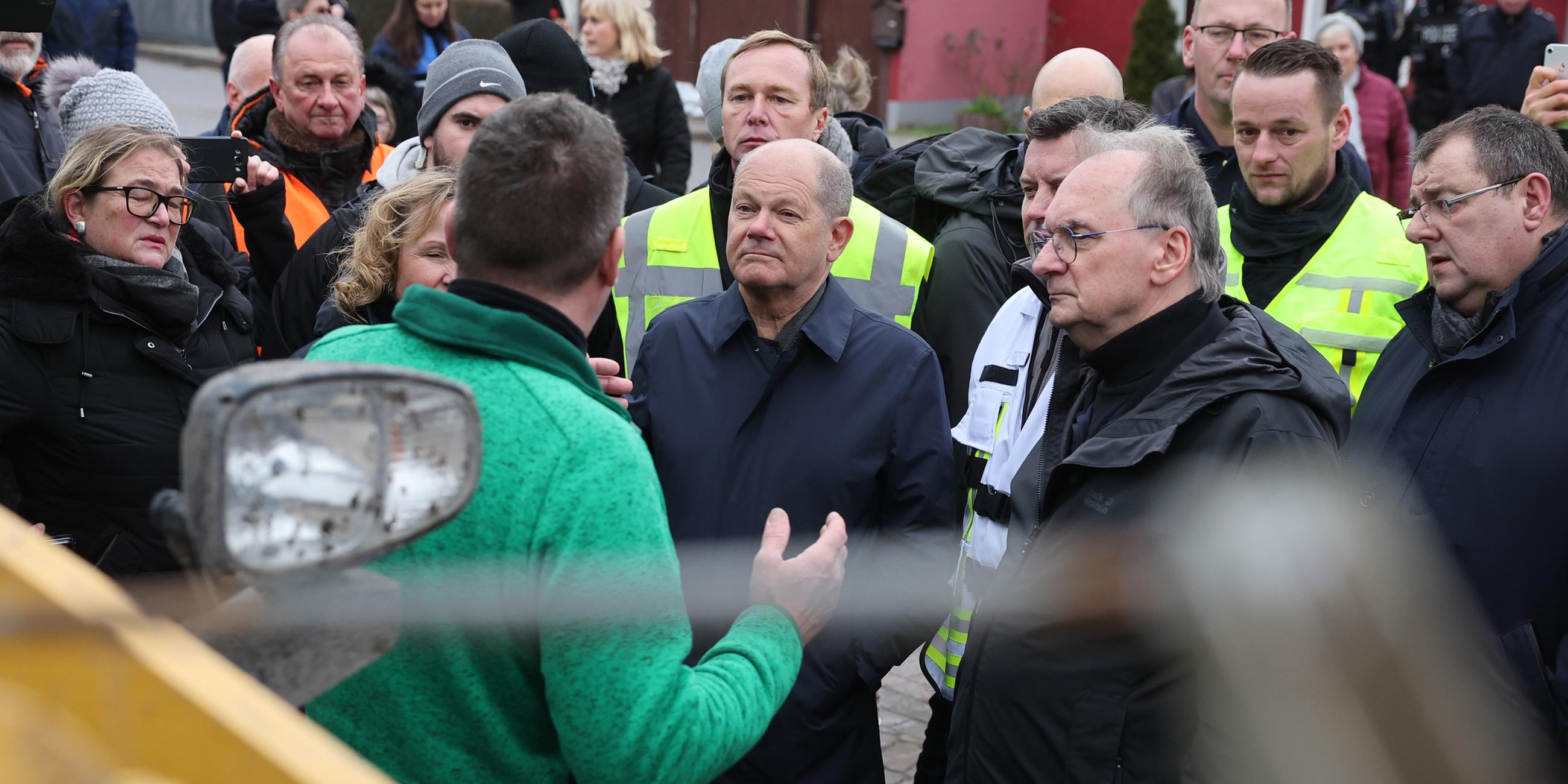 Olaf Scholz spricht am 04.01.2024 in Sangerhausen mit einem Helfer.