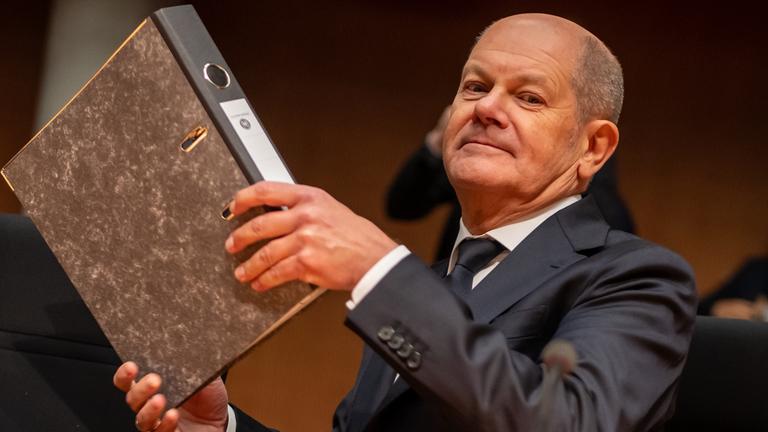 Olaf Scholz mit Aktenordner in der Hand