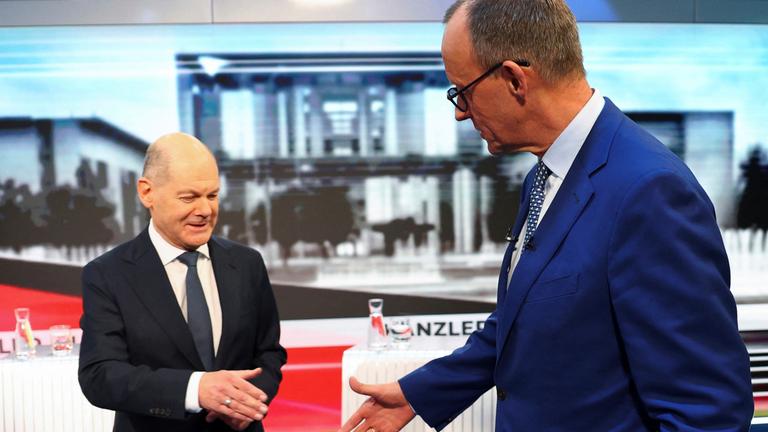 Olaf Scholz und Friedrich Merz begrüßen sich vor einer TV Debatte.