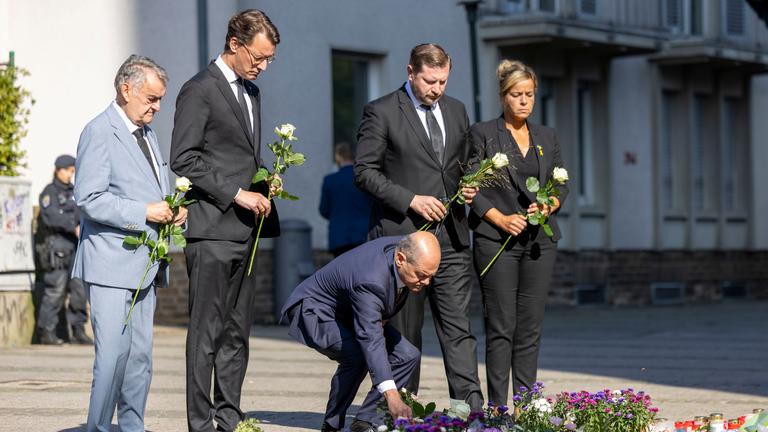 Olaf Scholz legt zusammen mit anderen Politikern Blumen in Solingen nieder