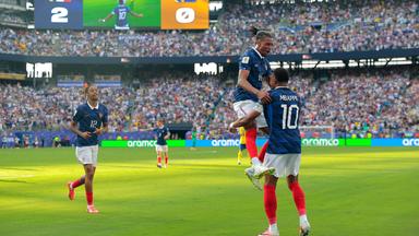 Michael Olise springt nach Frankreichs drittem Tor auf Torschütze Kylian Mbappe zu.