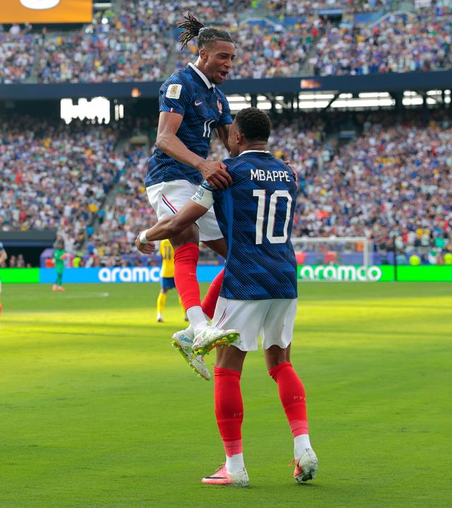 Michael Olise springt nach Frankreichs drittem Tor auf Torschütze Kylian Mbappe zu.