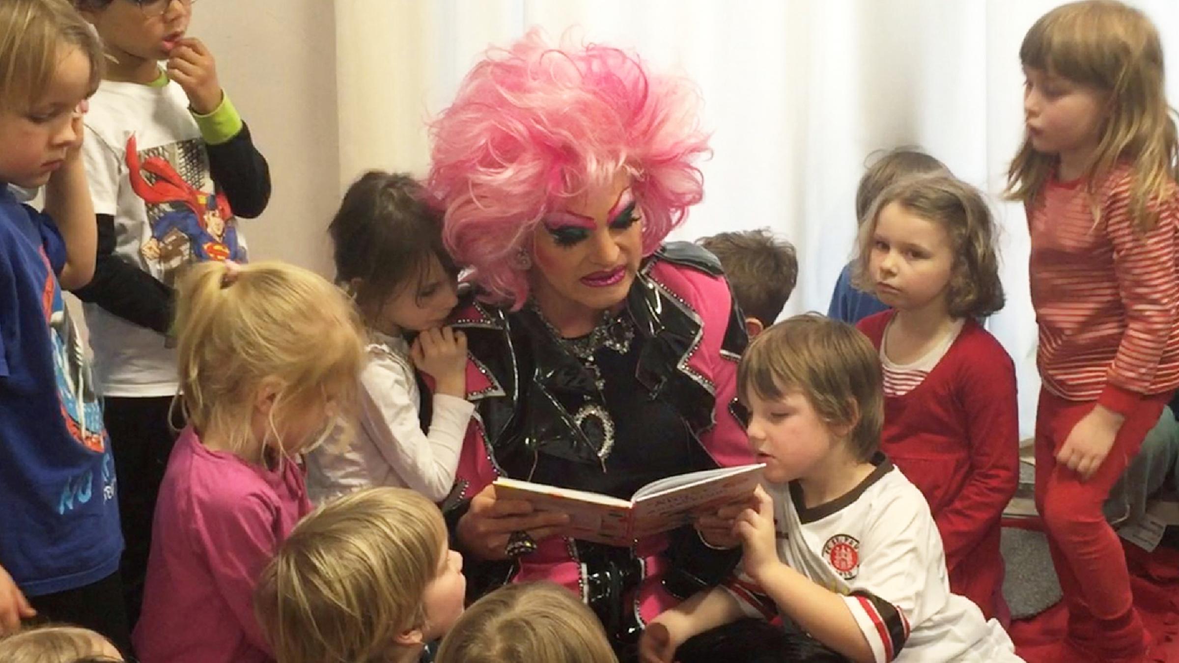 Olivia Jones liest Kindern ein Buch vor.