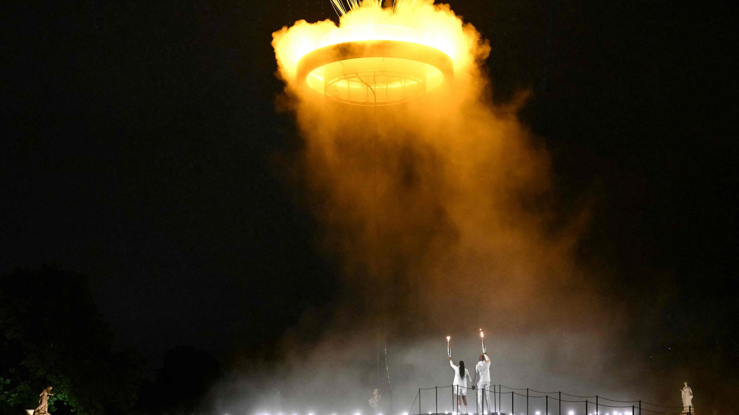 Der Kessel mit der angezündeten olympischen Flamme hebt ab, während er an einem Ballon befestigt ist