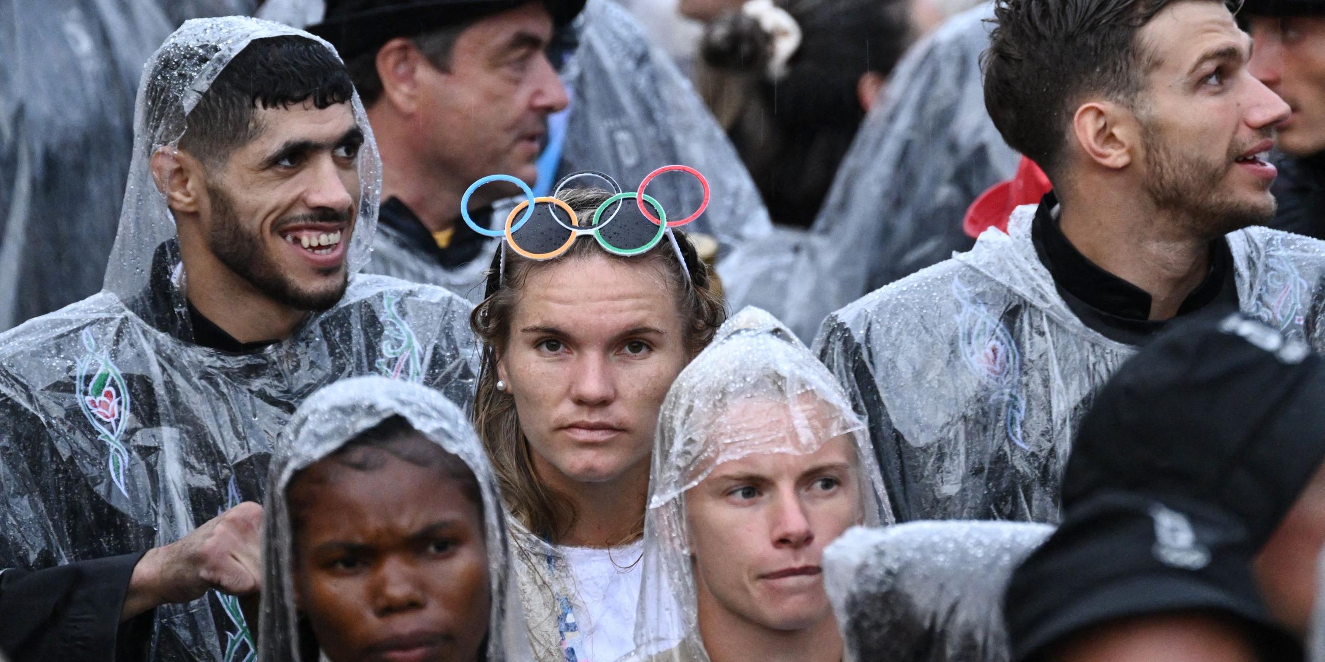 Während der Eröffnungsfeier besteigen deutsche Sportler in Regenponchos ein Boot bei der schwimmenden Parade auf der Seine.