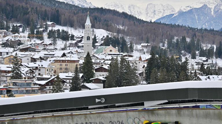 Bob, im Cortina Sliding Centre mit dem Schriftzug "Milano Cortina 2026". Im Hintergrund die Stadt Cortina.