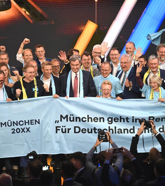 Der bayrische Ministerpräsident Söder und Mitglieder der Münchner Delegation jubeln auf der Bühne nach der Wahl des deutschen Olympia-Bewerbers für 2036, 2040 oder 2044.