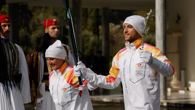 Die ersten von 10.000 Fakelläufern machen sich mit dem olympischen Feuer auf dem Weg von Olympia nach Mailand