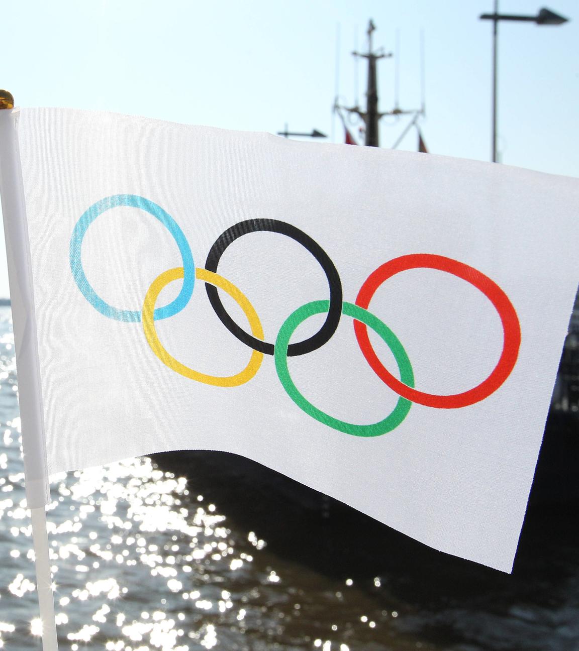 Eine Flagge mit den Olympischen Ringen hängt an einer Brücke im Hamburger Hafen.