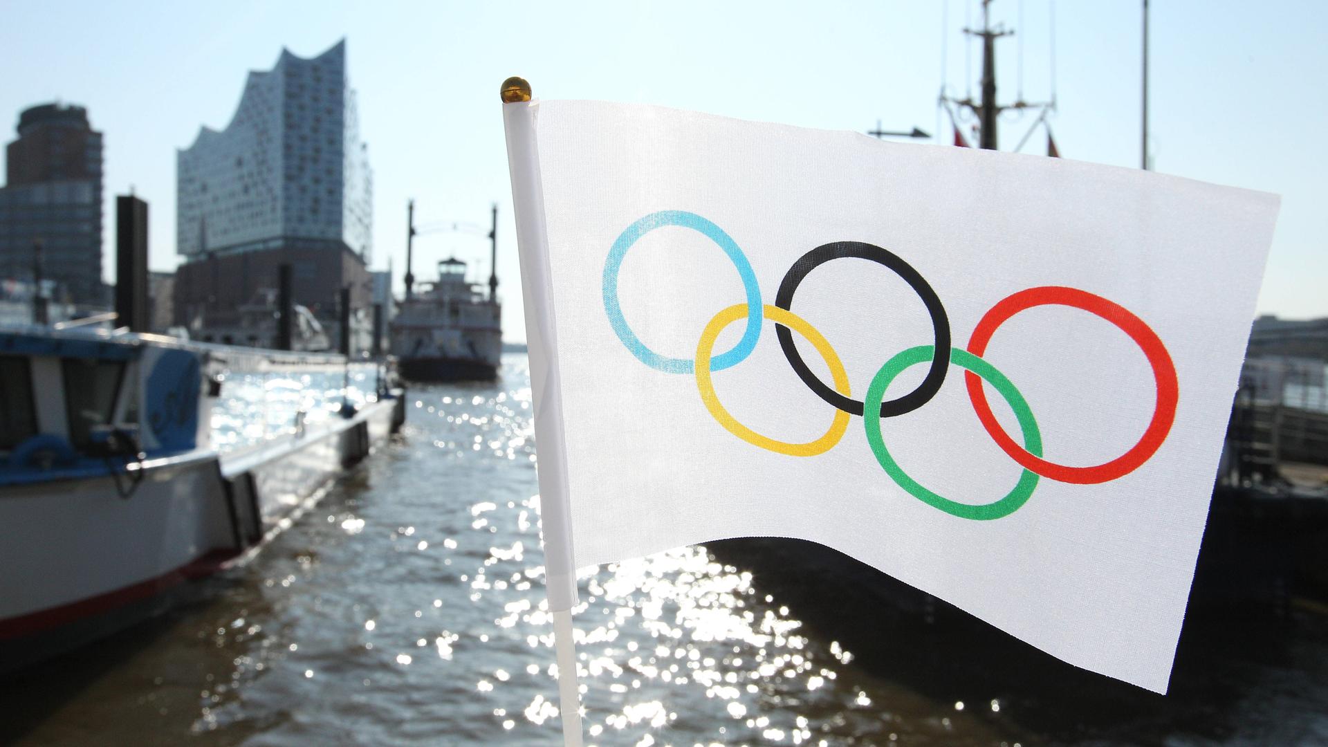 Eine Flagge mit den Olympischen Ringen hängt an einer Brücke im Hamburger Hafen.