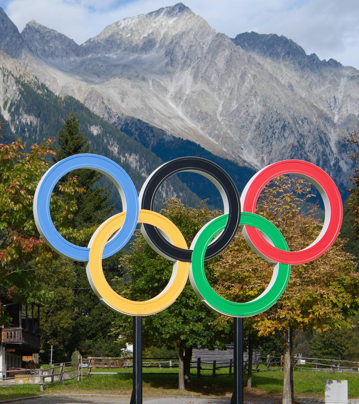 Olympia-Ringe in Cortina vor einem Haus in den Bergen.