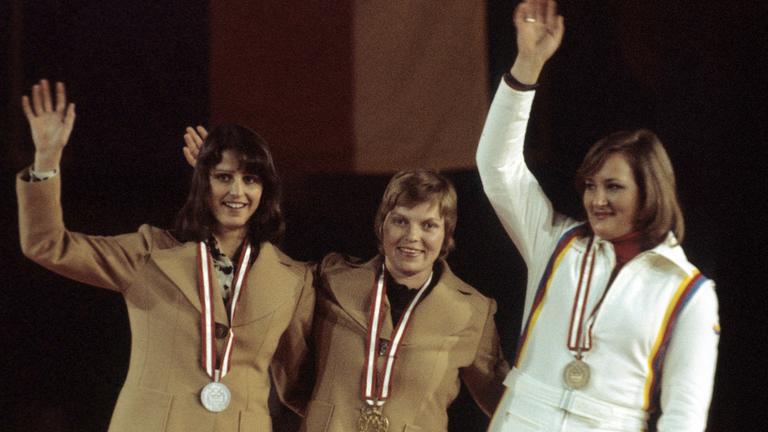 Bei der Olympischen Siegererhrung im Rodeln 1976 jubeln Ute Rührold, Margit Schumann und Elisabeth Demleitner ins Publikum