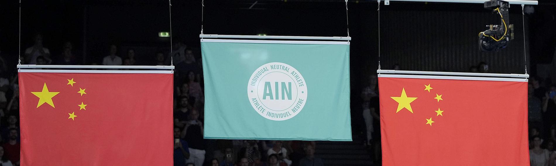 Eine Flagge, die einzelne neutrale Athleten repräsentiert (M.), wird gehisst, nachdem Ivan Litvinovich aus Weißrussland am 02.08.2024 in der Bercy Arena in Paris den Trampolinturnwettbewerb der Männer bei den Olympischen Spielen in Paris gewonnen hat