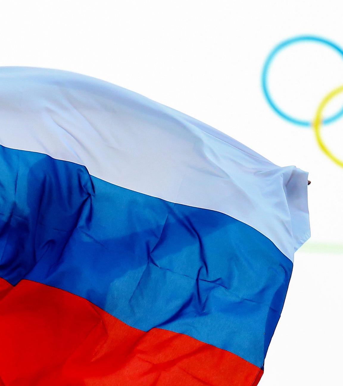 Ein Athlet aus Russland feiert mit einer Flagge nach einem Event bei den Olympischen Spielen 2014.