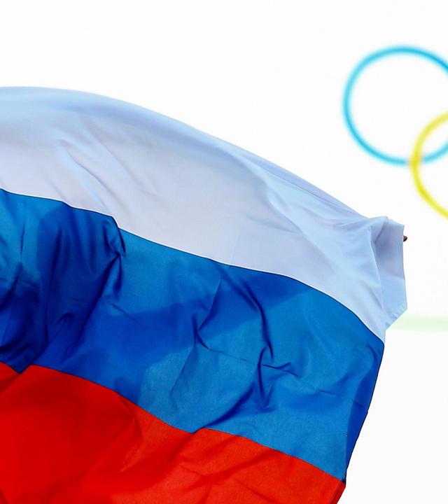 Ein Athlet aus Russland feiert mit einer Flagge nach einem Event bei den Olympischen Spielen 2014.