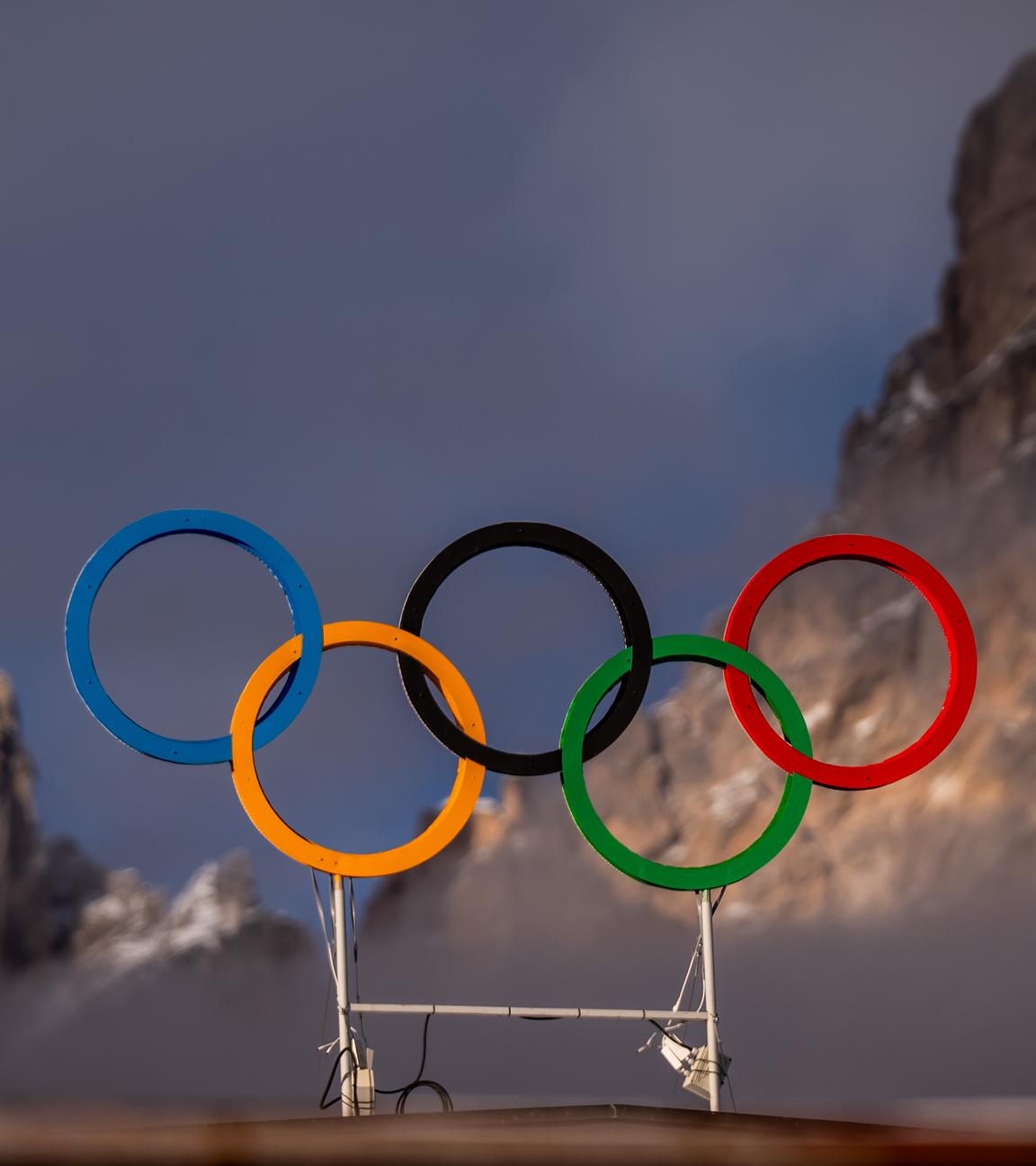 Die Olympischen Ringe auf dem Dach der Curling-Halle sind vor den Bergen in Cortina zu sehen.