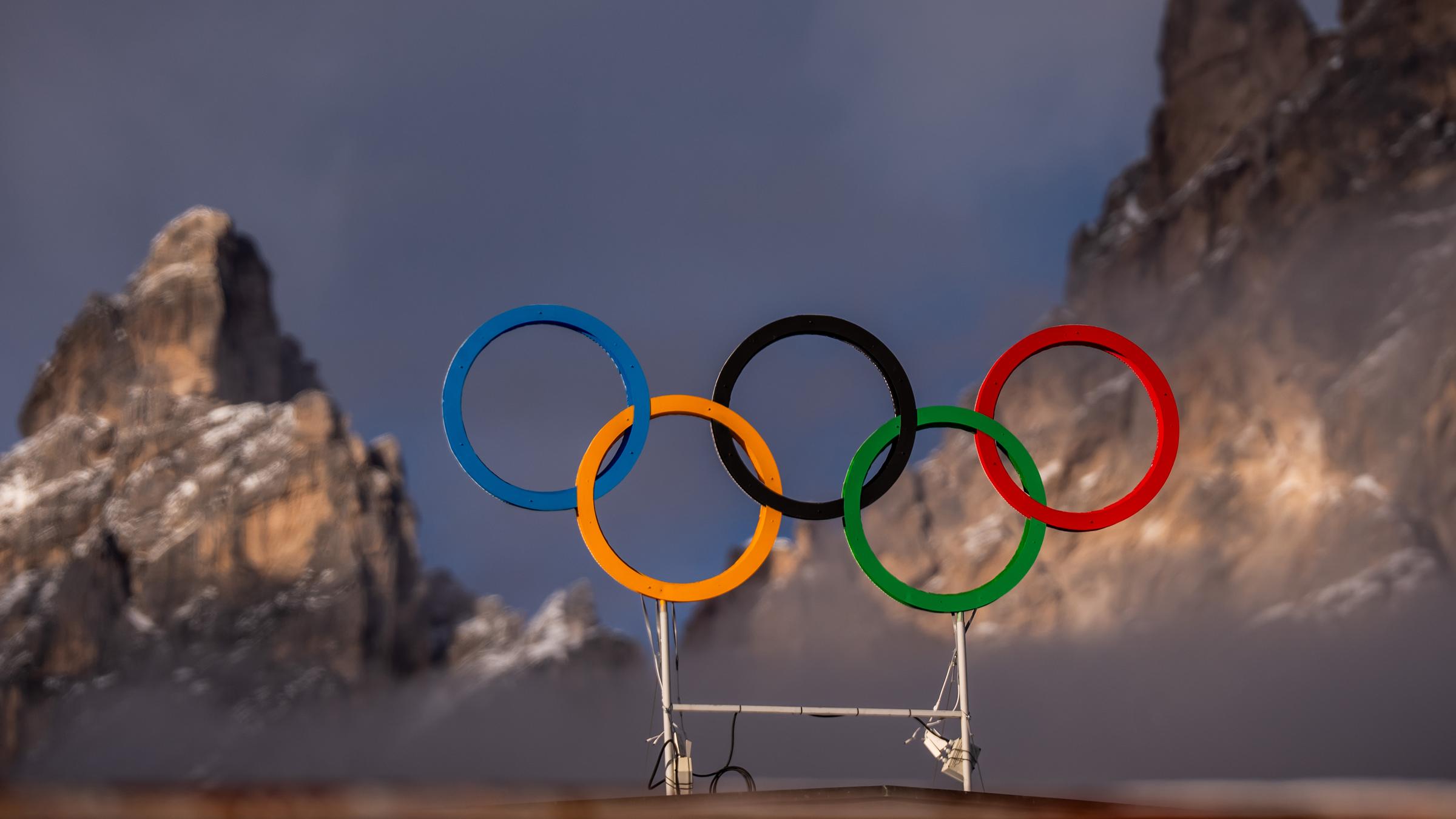 Die Olympischen Ringe auf dem Dach der Curling-Halle sind vor den Bergen in Cortina zu sehen.