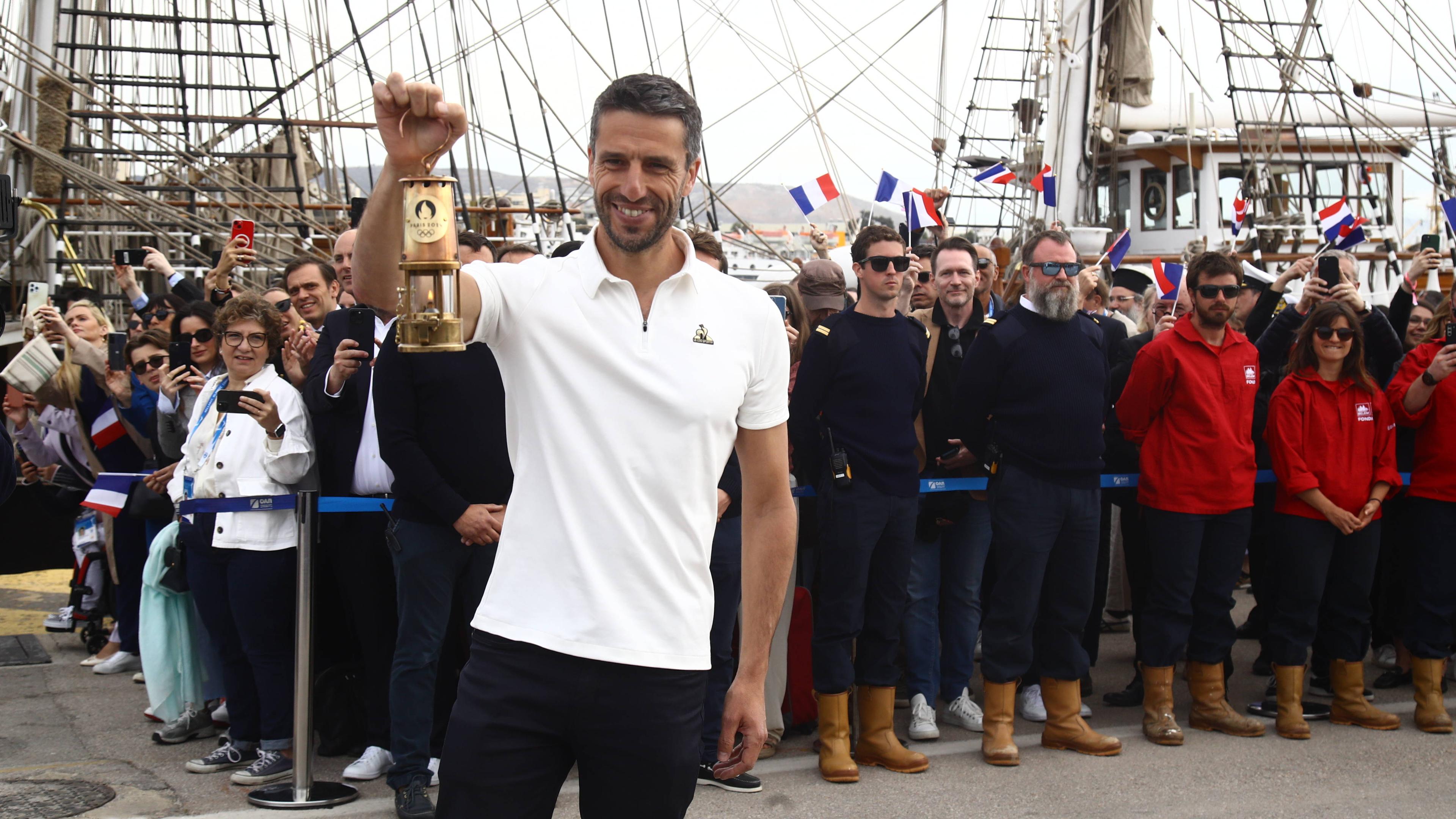 OK-Chef Tony Estanguet hält das Olympische Feuer.