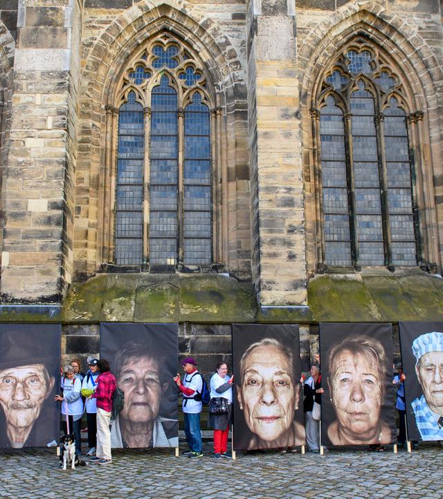 Sachsen-Anhalt, Magdeburg: "Omas gegen Rechts" und "Opas gegen Rechts" stehen mit Porträts von Holocaust-Überlebenden vor dem Dom von Magdeburg.