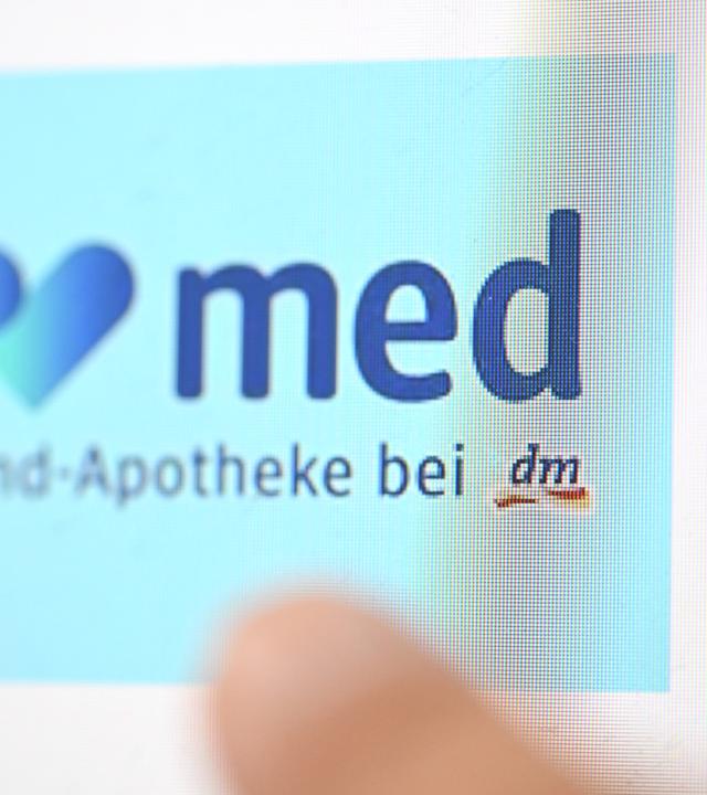 Das Logo der Online-Apotheke dm-med erscheint auf der Webseite von dm auf einem Computerbildschirm.