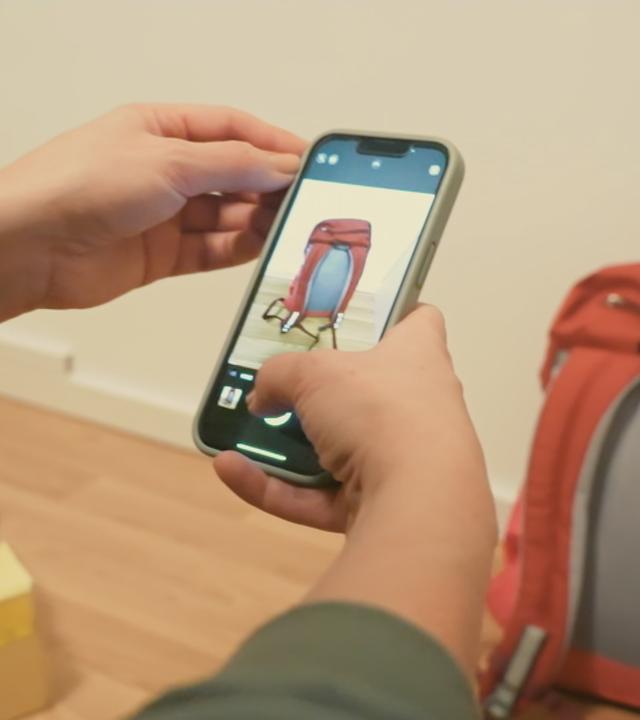 Mit einem Handy werden Fotos von einem Rucksack gemacht.