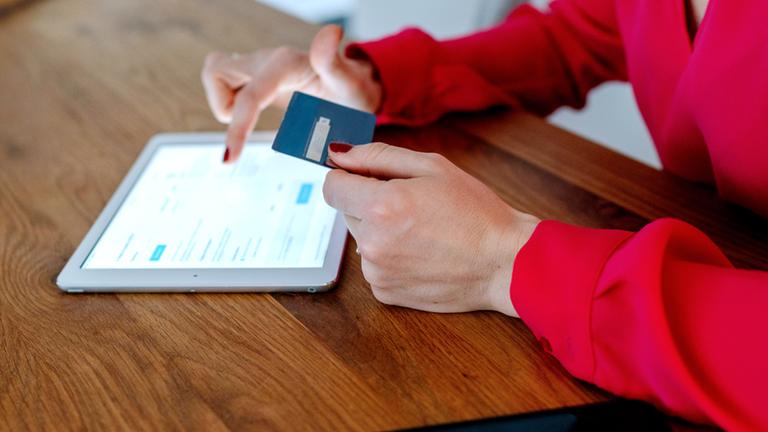 Frau mit EC-Karte beim Online-Shopping
