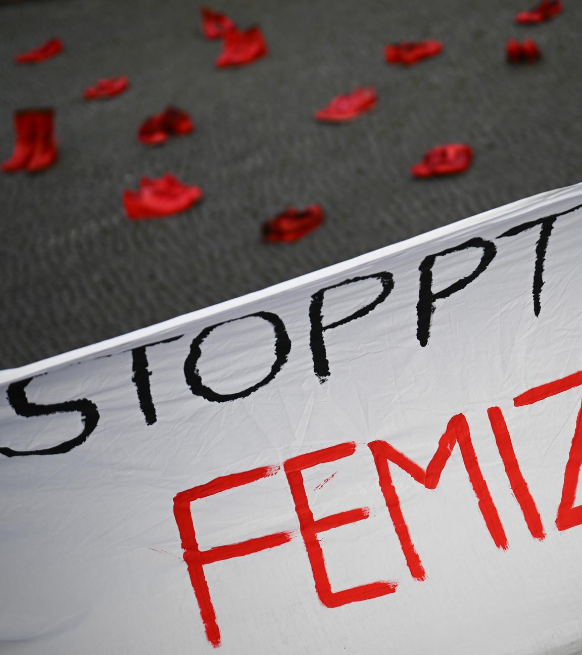 Weißes Banner mit roter Aufschrift "Stoppt Femizide