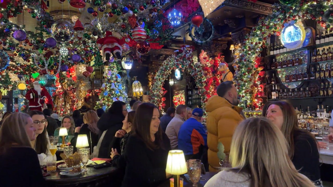 In der weihnachtlich geschmückten "Oscar Wilde" Bar sitzen Gäste.