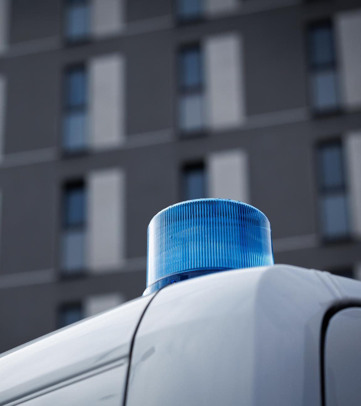Osnabrück: Das Blaulicht eines Polizeifahrzeugs ist vor einem Hochhaus zu sehen.