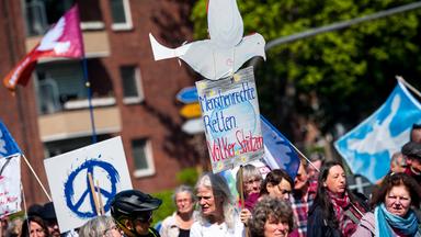 Hamburg: Teilnehmer eines Ostermarsches ziehen mit einem Schild mit der Aufschrift "Menschenrechte retten. Völker schützen"