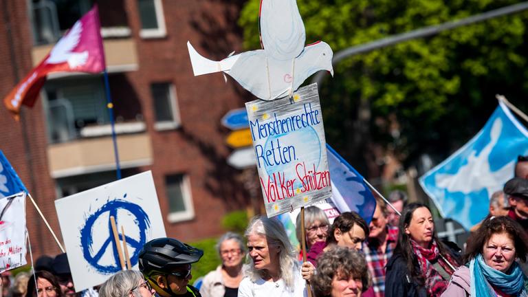 Hamburg: Teilnehmer eines Ostermarsches ziehen mit einem Schild mit der Aufschrift "Menschenrechte retten. Völker schützen"