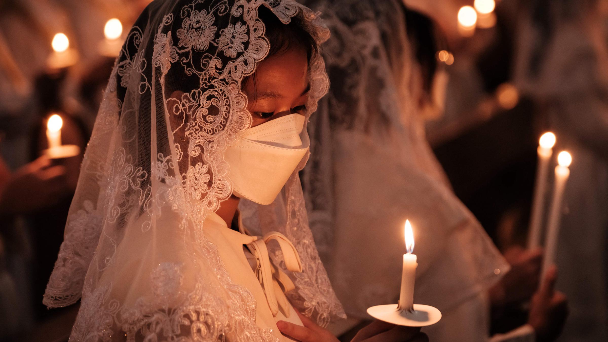 Katholische Gläubige halten Kerzen während der Osternacht in der Kirche St. Kristoforos in Jakarta am 30.03.2024.