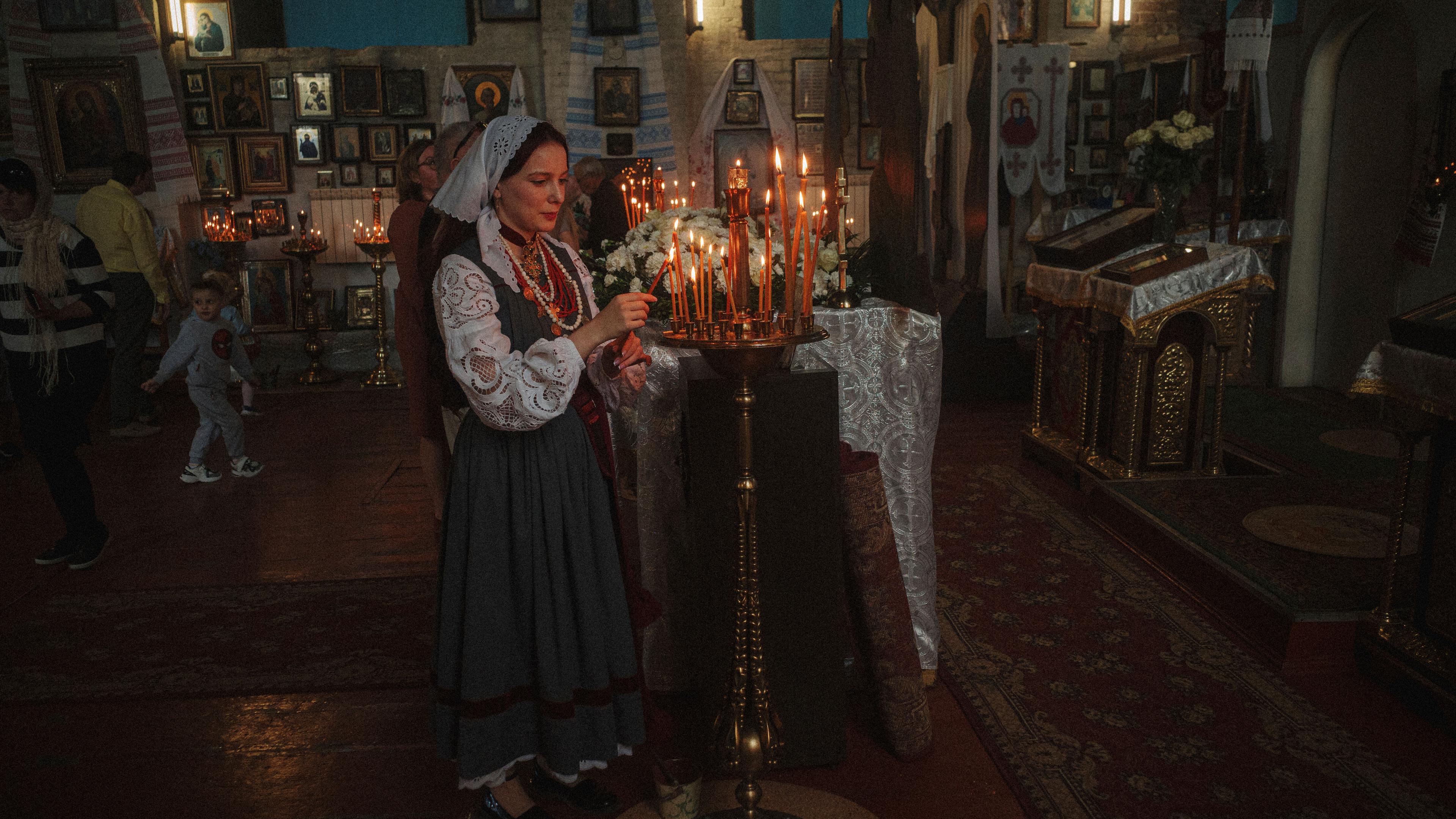 Eine Frau entzündet eine Kerze während der orthodoxen Osterfeier in der Johannes-Theologen-Kirche der Orthodoxen Kirche der Ukraine in Charkiw. 