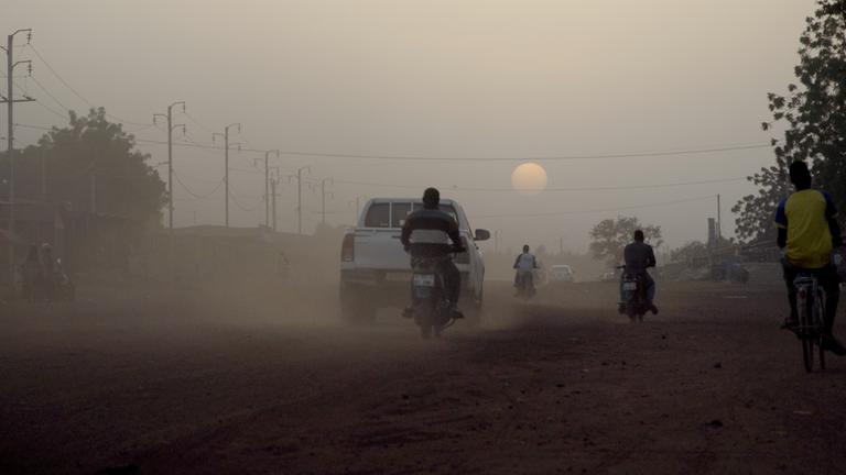 Verkehr auf einer staubigen Straße.