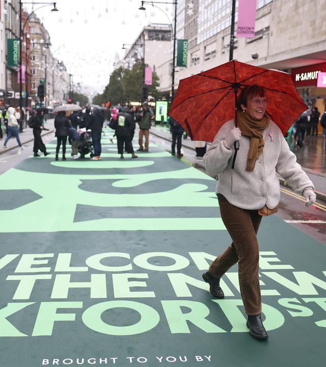 Menschen gehen auf der ehemaligen Fahrbahn der Oxford Street in London, Großbritannien.