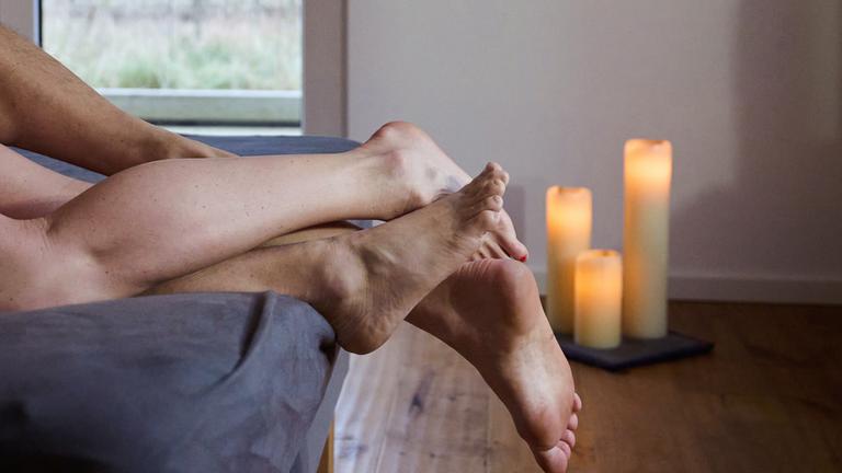 Eine Frau und ein Mann liegen eng umschlungen in einem Bett.