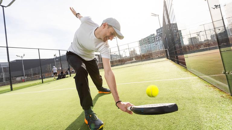 Ein Padelspieler mit Schläger und Ball