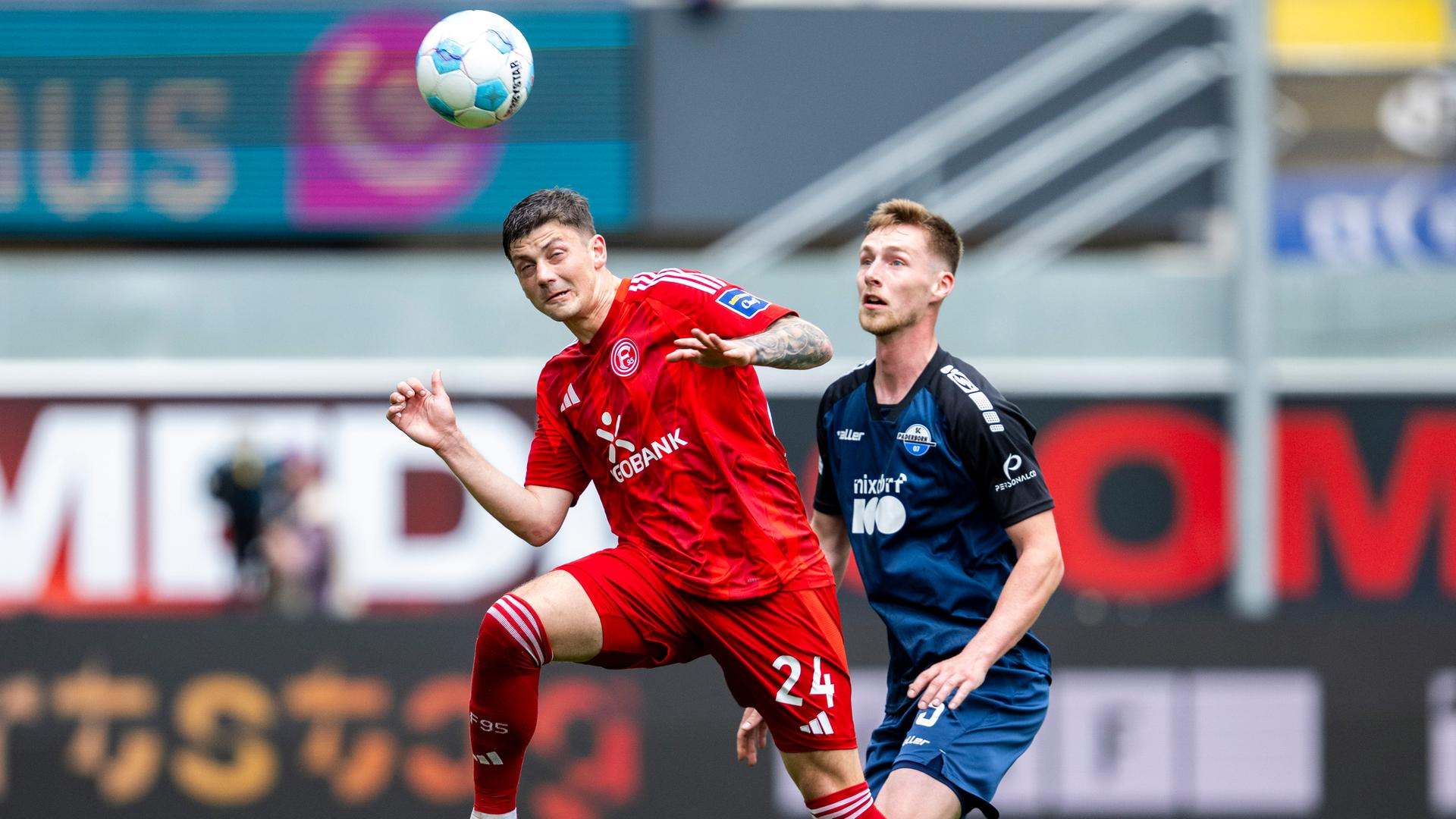 Düsseldorfs Dawid Kownacki und Paderborns Tjark Scheller kämpfen um den Ball beim Spiel am 13.04.2025.