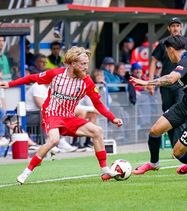 Freiburgs Flügelspieler Niklas Beste versucht, seinen Paderborner Gegenspieler Raphael Obermair im Zweikampf ins Leere laufen zu lassen.