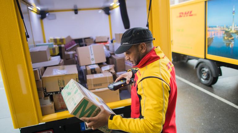 Paketbote scannt Pakete ein