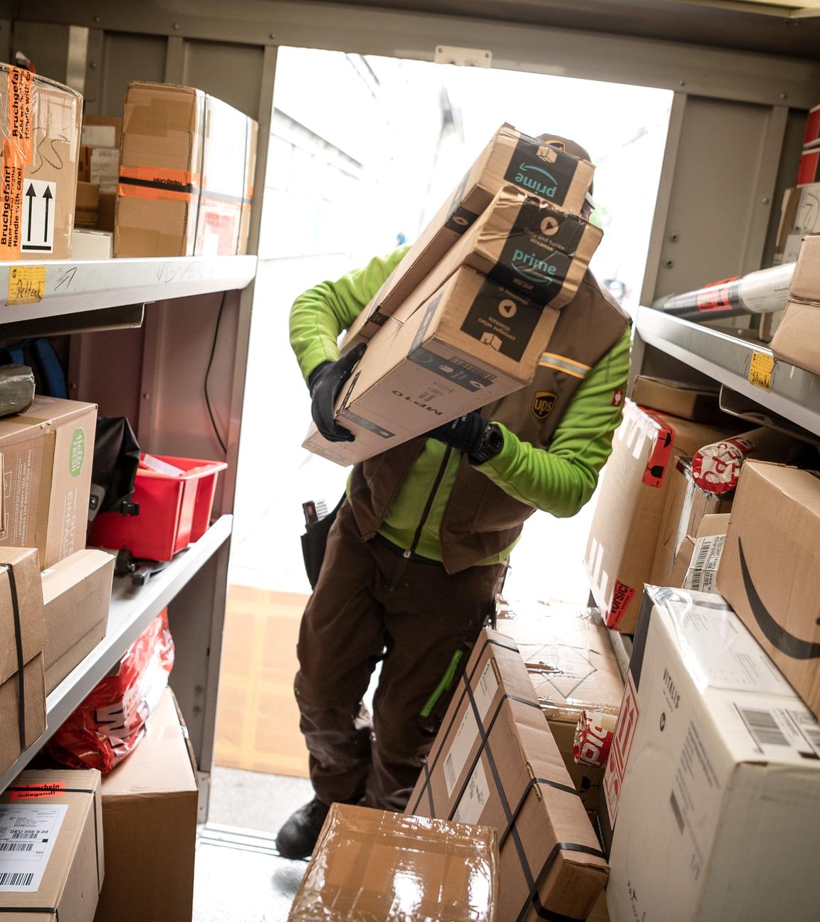 Ein Paketbote von UPS lädt Pakete in einen Transporter.