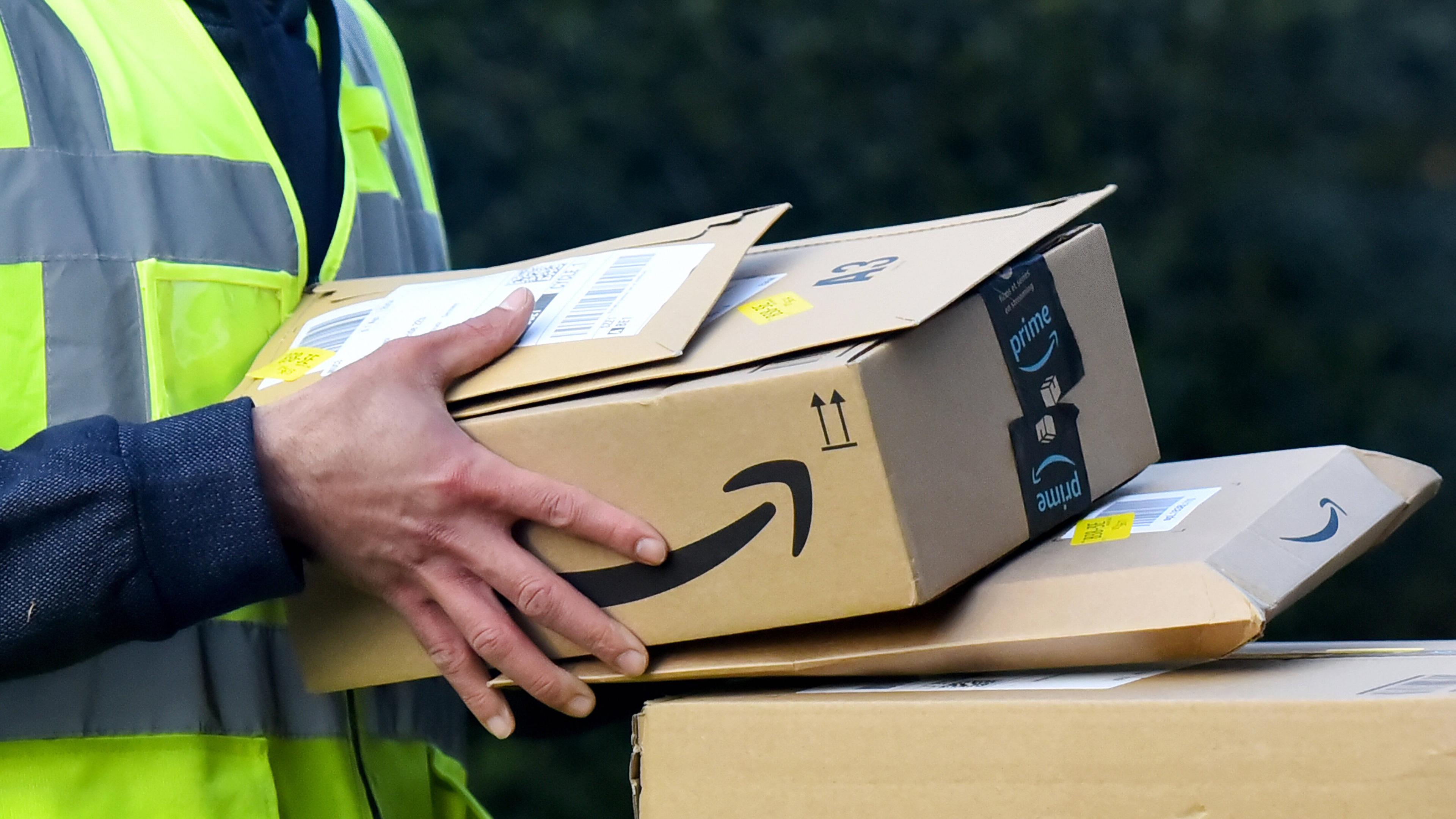 Mann trägt Amazonpakete aus (Symbolbild für Mindestlohn).