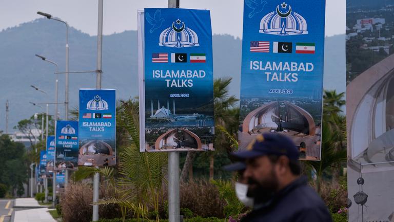 Sicherheitspersonal steht neben Schildern zu den Verhandlungen zwischen den USA und dem Iran vor einem Medienzentrum in Islamabad, Pakistan.