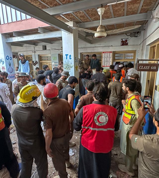 Rettungskräfte und Freiwillige beteiligen sich an den Rettungsarbeiten am Ort eines Dacheinsturzes an einer Privatschule in Peshawar.