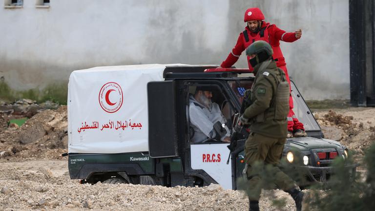 Israelische Soldaten beobachten, wie Mitglieder des Palästinensischen Roten Halbmonds (PRCS) Palästinensern beim Verlassen des Flüchtlingslagers Nur Shams nahe der Westjordanland-Stadt Tulkarem helfen