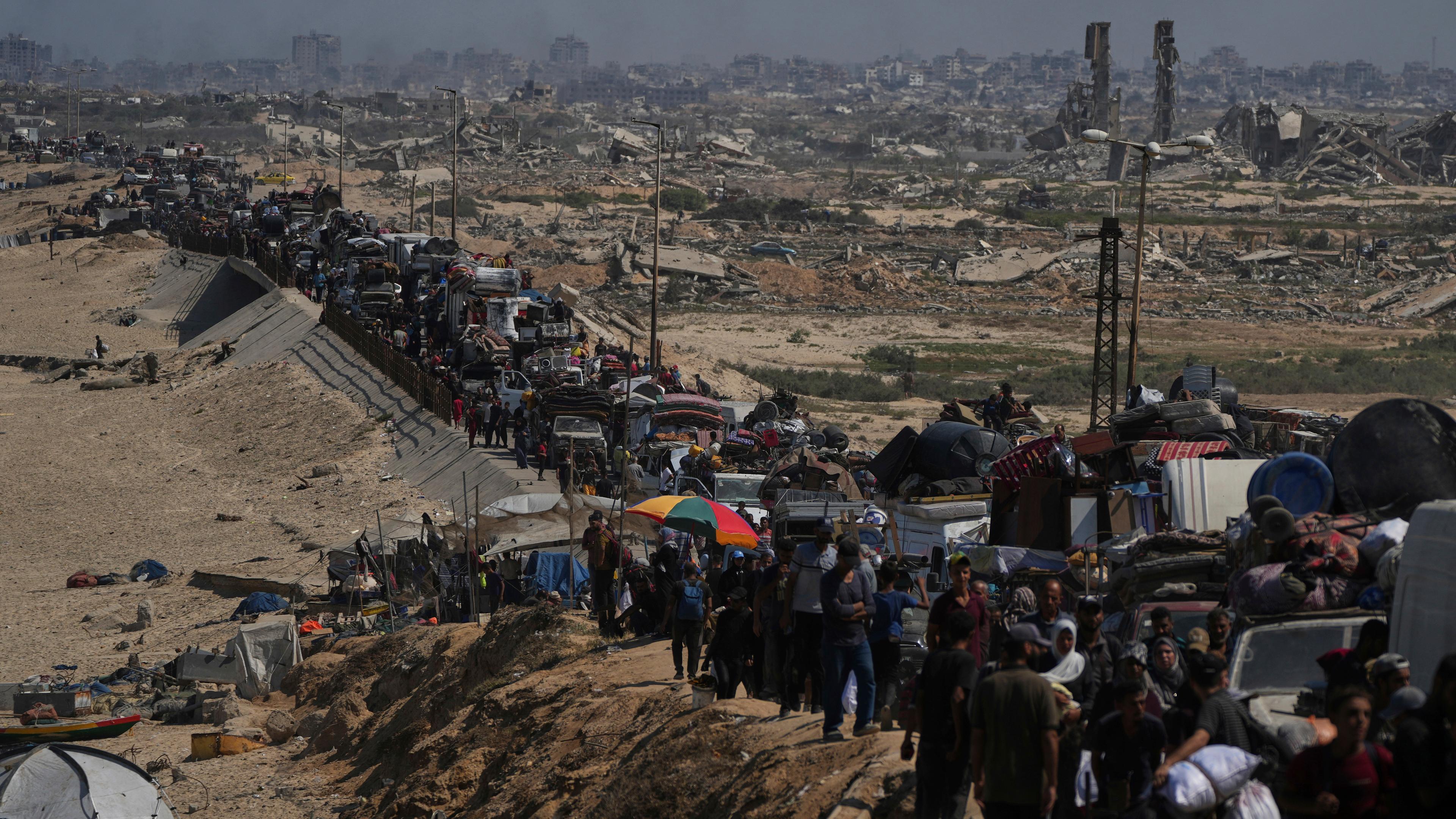Eine Reihe von Menschen mit ihrem Besitz ist auf einer Straße im Norden Gazas zu sehen - sie fliehen vor einer israelischen Militäroperation.