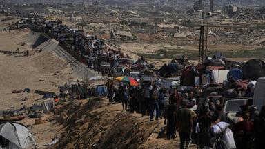 Eine Reihe von Menschen mit ihrem Besitz ist auf einer Straße im Norden Gazas zu sehen - sie fliehen vor einer israelischen Militäroperation.